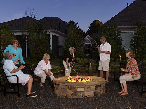 Neighbors gather around firepit for smores>